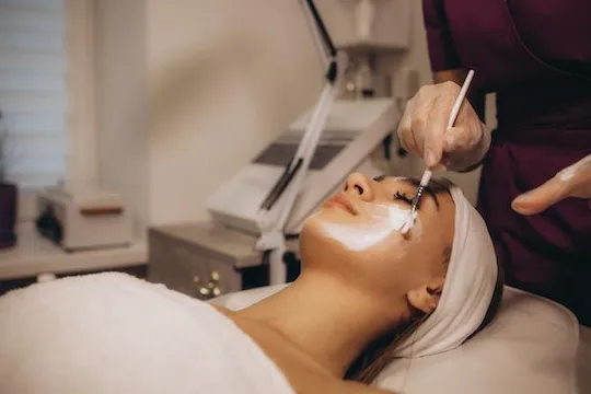 Esthetician applying a facial treatment to a guest