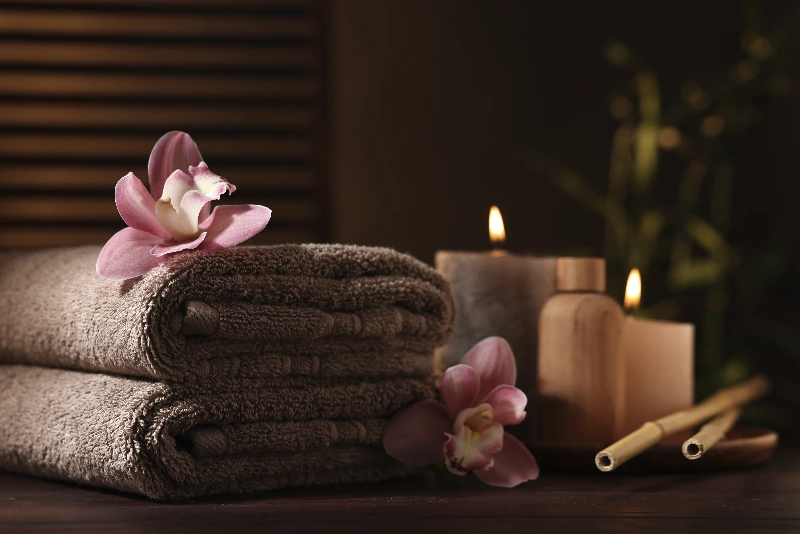 Soft spa atmosphere with rolled terry towels and lit candles